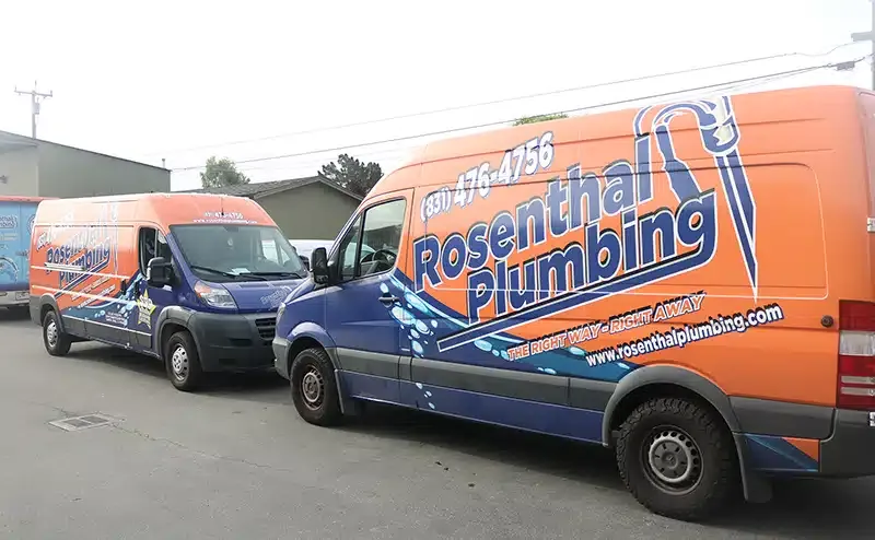 two rosenthal plumbing trucks parked together.